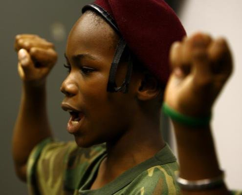 A Young Maroon in a maroon beret with fists raised